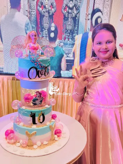A spectacular mermaid-themed rotating cake for a 10th birthday. This multi-tier creation features a mermaid doll, under-the-sea details, and a rotating center with bubble effects.