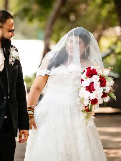 A sweet, candid moment as the groom looks at his bride through her veil. It's a simple, unposed interaction that is full of anticipation and affection.