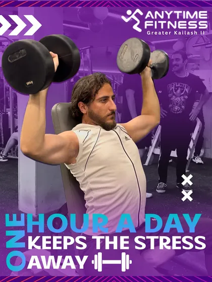 One hour a day keeps the stress away. A member performs a dumbbell shoulder press, building upper body strength.