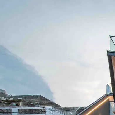 An upward view of the dramatic, intersecting planes of the Casa Acentuada façade against the sky.