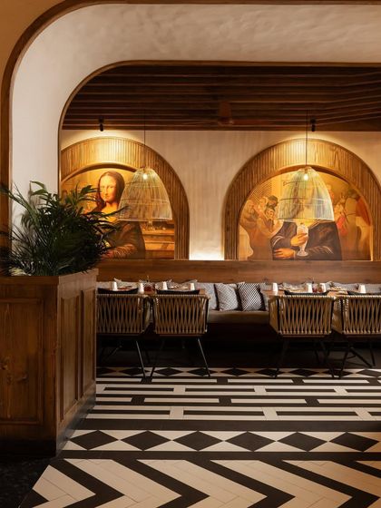 Arched openings frame views of the interior, which features custom murals that reinterpret classical paintings with a playful twist.