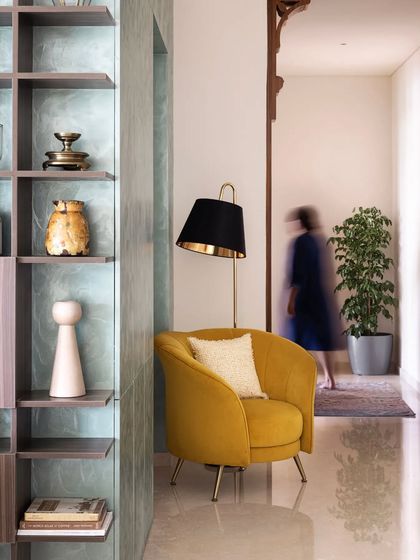 In the foyer, this open-closed shelving unit has a textured backdrop, creating visual continuity with the concealed storage. It displays a vast assortment of items that summarize the home's soul.