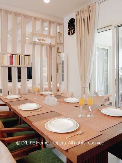 Another view of this elegant dining area, showcasing the wooden table and chairs set against a light, neutral backdrop. The design emphasizes natural light and a connection to the balcony space.