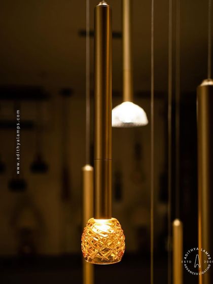 This cluster pendant features a mix of gold-toned rods with textured glass shades, some resembling pineapples and others simple domes. The combination creates a visually interesting and warm installation for any corner that needs a lift.