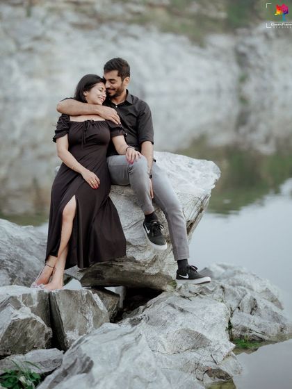 A candid moment of affection by a calm lake. The natural setting and the couple's relaxed posture make this a perfect example of a peaceful, intimate pre-wedding portrait.