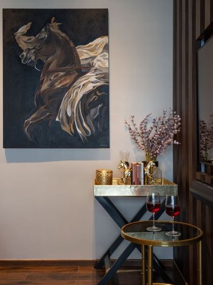 A realistic painting of a horse in motion, its form blending with flowing fabric. This dramatic, dark-toned canvas adds a sense of power and elegance to this cozy corner.