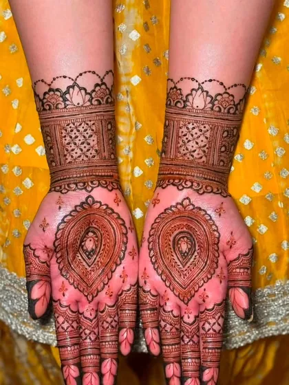 A beautiful, delicate design on the palms with a central paisley motif, showing the rich stain of my henna.