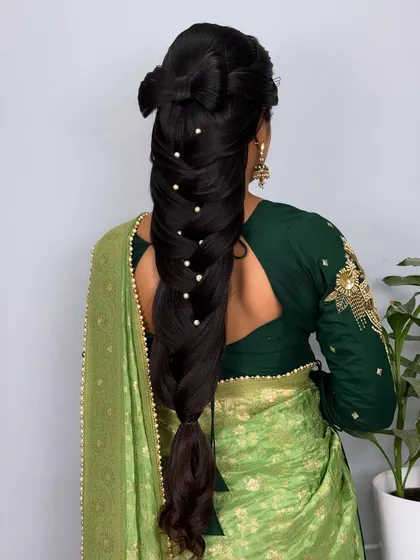 The full back view of the intricate long braid with a hair bow.
