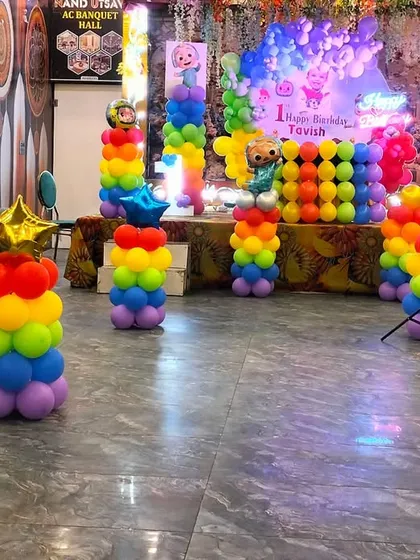 This image shows the layout of the Cocomelon party in the banquet hall, with rainbow balloon pillars placed throughout the seating area to extend the theme.