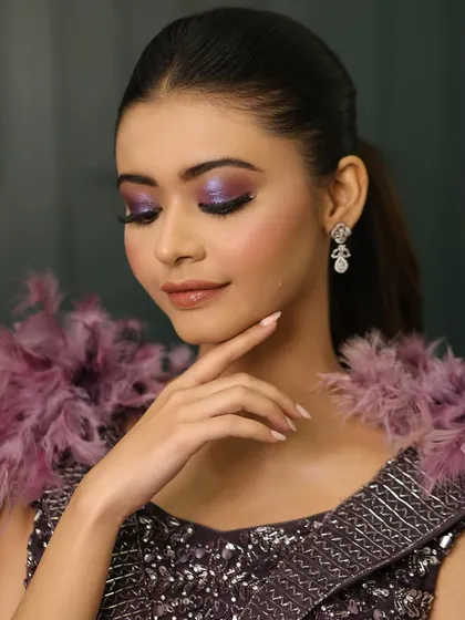 The side profile shows how the sleek ponytail balances the drama of the makeup and the outfit. It's a look that is both edgy and sophisticated.