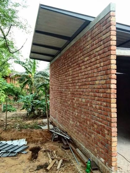 A detail shot during the construction of the Artist Residency. This image highlights the simple, honest junction of a steel roof plane resting on an exposed fire brick wall, showcasing the beauty in the clear expression of structural elements.