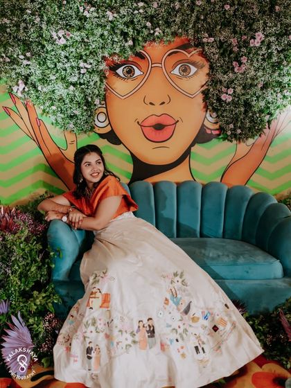 Another fun shot of the bride posing against the quirky floral mural at her party.