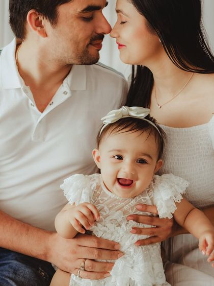 A close-up shot full of love and laughter. The baby's happy smile is infectious in this intimate family portrait.
