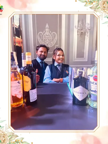 Our mixologists Tina and Omkar are ready for service. This photo shows our team's readiness and the premium selection of spirits, like Hendrick's Gin, that we work with.