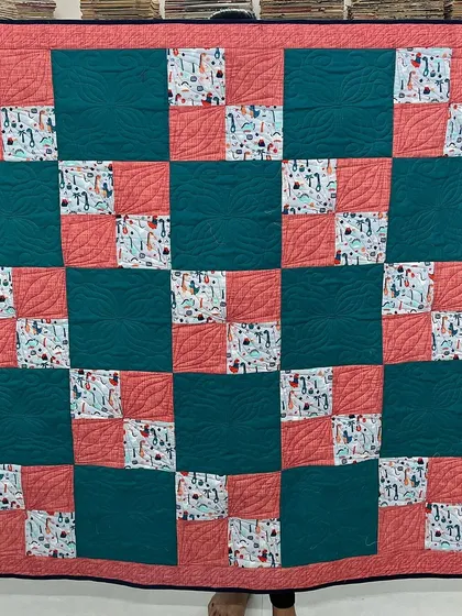 A 4-patch quilt made with fun dinosaur-print fabric, perfect for a child's room.