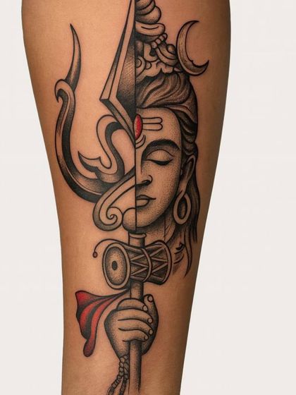 This design is a powerful fusion of Mahadev's face and his Trishul. The clean, bold lines and the split design represent the balance between peace and power. The red bindi adds a striking pop of color, making it a unique and modern take on a classic spiritual symbol.