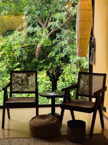 A quiet seating nook with classic rattan chairs, perfect for reading a book or having a conversation while surrounded by the sights and sounds of the forest.