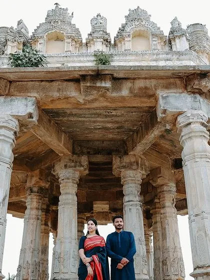 A powerful, symmetrical shot of the couple standing at the center of the temple's stone structure. This composition is classic, strong, and full of cultural significance.