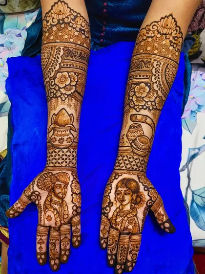 This full bridal design showcases traditional Maharashtrian wedding elements. It features couple portraits on the palms, along with a 'kalash' and other symbolic motifs on the arms.