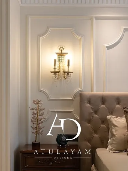 A close-up of the classic bedroom's tufted headboard and ornate wall sconce, highlighting the room's elegant and non-stuffy design.