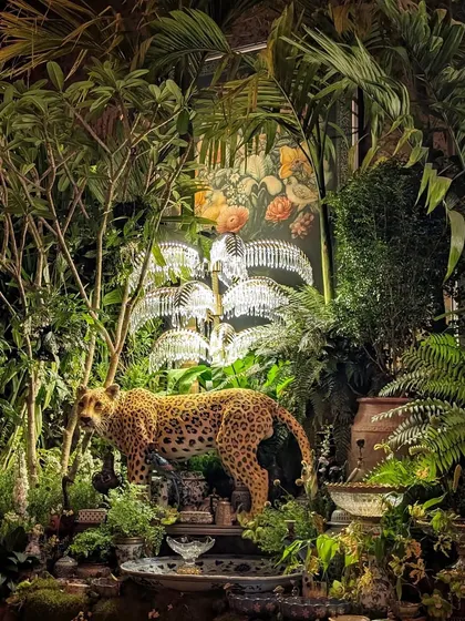 A stunning composition from the Sabyasachi event, where a leopard statue is nestled within a jungle of palms and Frangipani trees. The scene is illuminated by crystal palm tree lamps, blending our greenery with the event's luxurious design elements.
