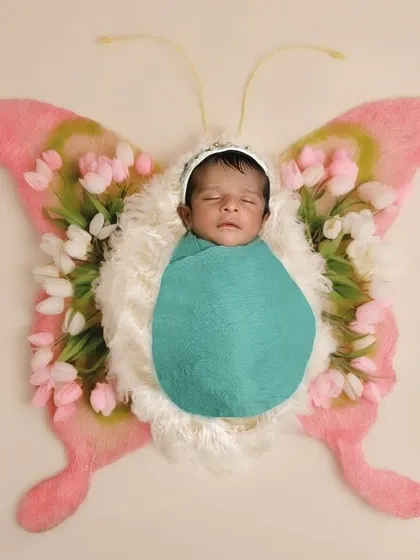 A beautiful butterfly theme, with the baby as the centerpiece. This is a lovely, artistic concept that symbolizes transformation and new beginnings.
