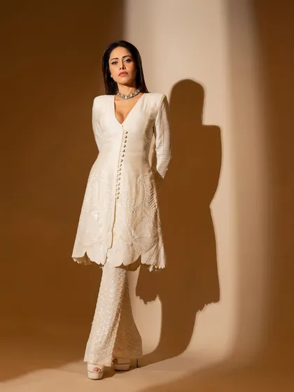 This ivory kurta and flared pants set on Nushrratt Bharuccha is all about classic elegance. The delicate embroidery and button details make it a timeless piece for any special occasion.