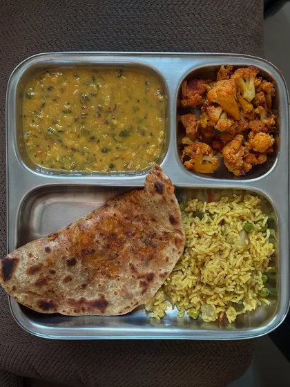 A comforting meal of stuffed paratha, dal, vegetable pulao, and cauliflower palya. This plate is a great example of a hearty yet healthy Indian lunch.
