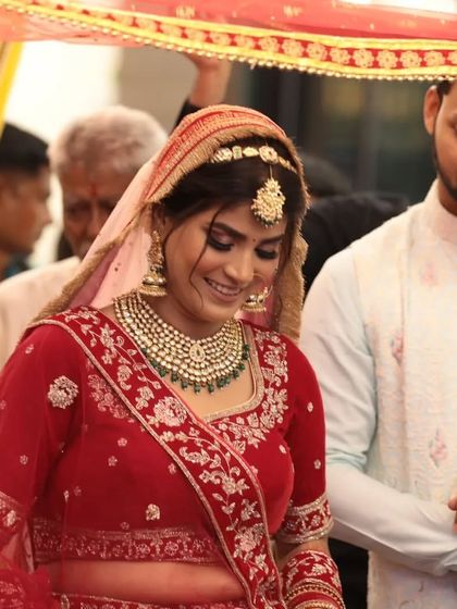 The bridal entry is a moment to remember. This bride looks serene and beautiful under the phoolon ki chadar, her Kundan necklace adding to her glow.