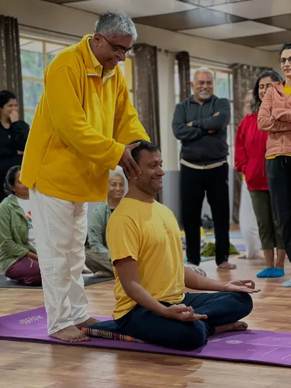 A student smiles as I help him align his head and neck for pranayama. A comfortable and steady posture is the foundation for any successful meditation or breathing practice.
