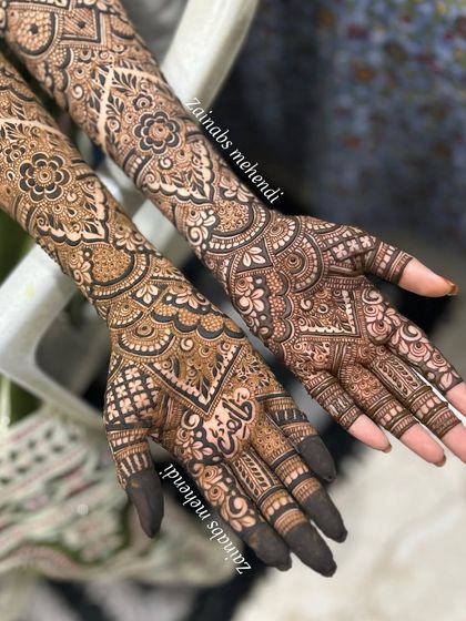 A symmetrical shot of Madeeha's bridal henna on both hands, showcasing the intricate and matching designs.