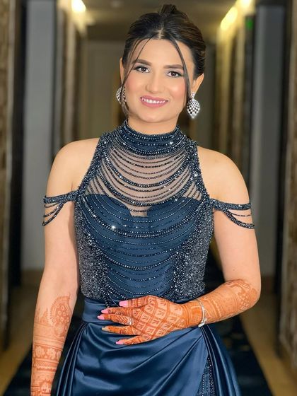 Aditi on her engagement day, looking chic and modern in a beaded navy blue gown. Her makeup is sophisticated and elegant.