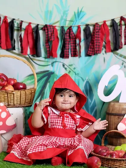 Our little model dressed as Little Red Riding Hood. The red cape adds a pop of color against the green, woodsy backdrop.