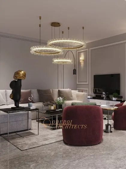 The circular pendant lights and plush burgundy armchairs create a cozy and inviting corner within the larger family lounge.