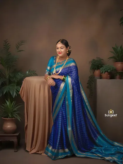 A graceful pose against a simple studio setup with indoor plants. This highlights the elegance of the saree and the beauty of the mother-to-be.