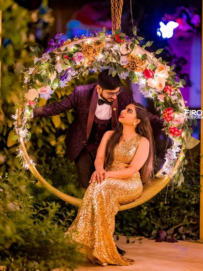 A glamorous couple enjoying a moment on our floral swing, illuminated by soft lights. This setup is ideal for elegant and romantic evening portraits.