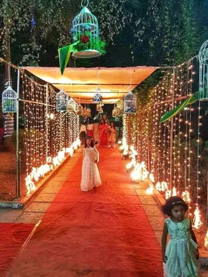 To make a grand entrance, I design illuminated walkways like this one. This tunnel is lined with fairy lights and hanging bird cages, creating a beautiful path for guests as they arrive at the event.