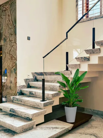 The staircase in our "House Reversed" project is a work of art, with cantilevered steps made of Palamino marble and a sleek, modern glass railing.