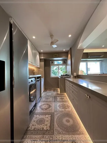 This galley-style kitchen is part of a larger open-concept space, designed with a long serving counter that connects it to the living area. The layout is perfect for entertaining and daily family life.