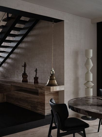 We incorporated a traditional brass temple bell into the dining area, hanging it next to a modern, minimalist console. This juxtaposition of old and new is a hallmark of our design style.