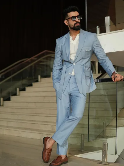 Our design philosophy blends classic tailoring with modern functionality. This custom ice-blue suit features a unique belted jacket and safari-style pockets, offering a contemporary yet sophisticated option that stands apart from traditional suiting.