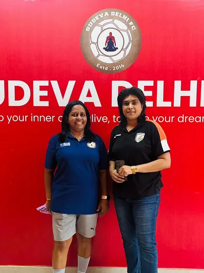 A photo of our coach with Ms. Neha Chauhan in front of our motto: "Keep your inner child alive, to keep your dreams alive."