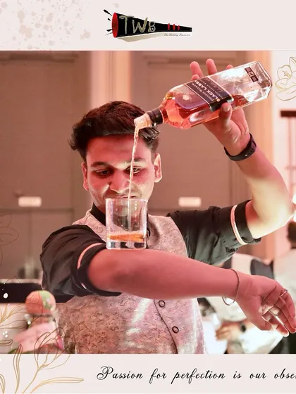 A bartender performs an "elbow pour," a classic flair move that adds a bit of showmanship to the service.