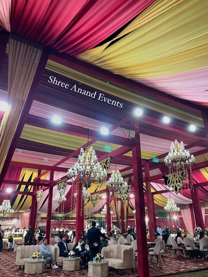 An upward-looking shot of the colorful draped ceiling and the numerous chandeliers that illuminate the entire event space.