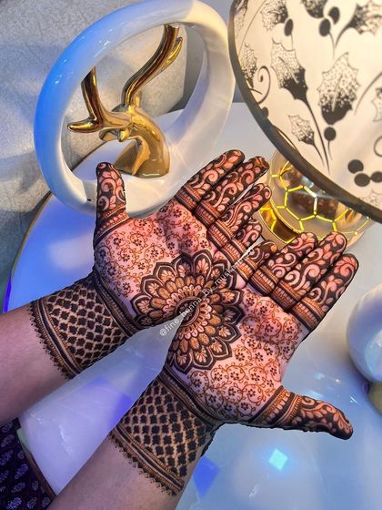 A beautiful non-bridal design with a central floral mandala and a net pattern on the wrist.