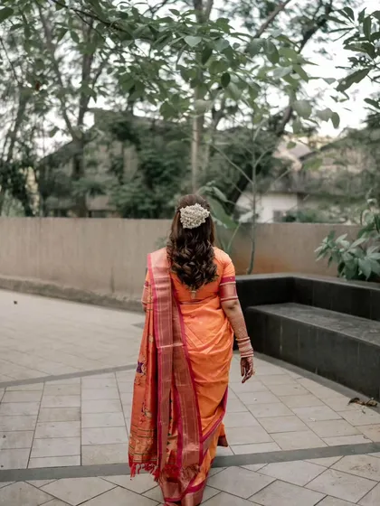 A back view of the bride's hairstyle, showing the soft waves and the simple, elegant hair accessory.