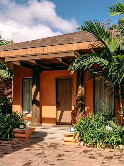 The entrance to one of our private bungalows, surrounded by lush greenery and a cobblestone path. This is the first glimpse of the peaceful and exclusive experience that awaits you.