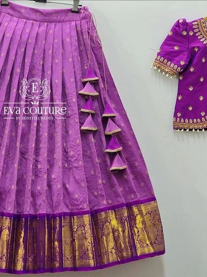 A deconstructed view of a purple half-saree set, showing the embroidered blouse and the Kanchi Pattu skirt.