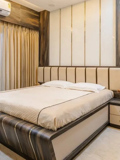 A bedroom design in Mahad featuring a vertically paneled headboard and a sleek, modern vanity table. The use of mixed wood grains adds warmth and texture to the room.