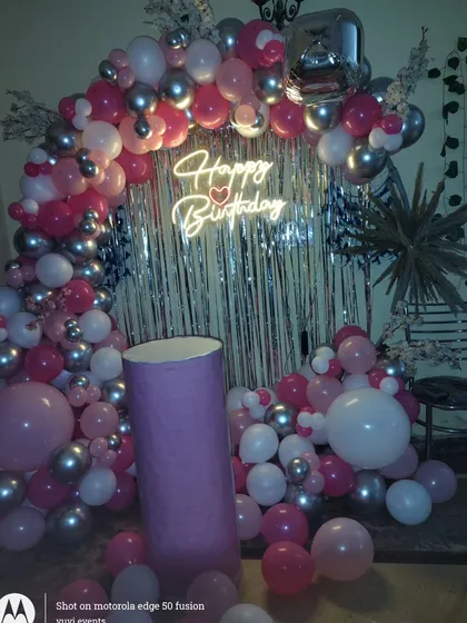 A close-up of the neon sign and balloon details for the birthday party.